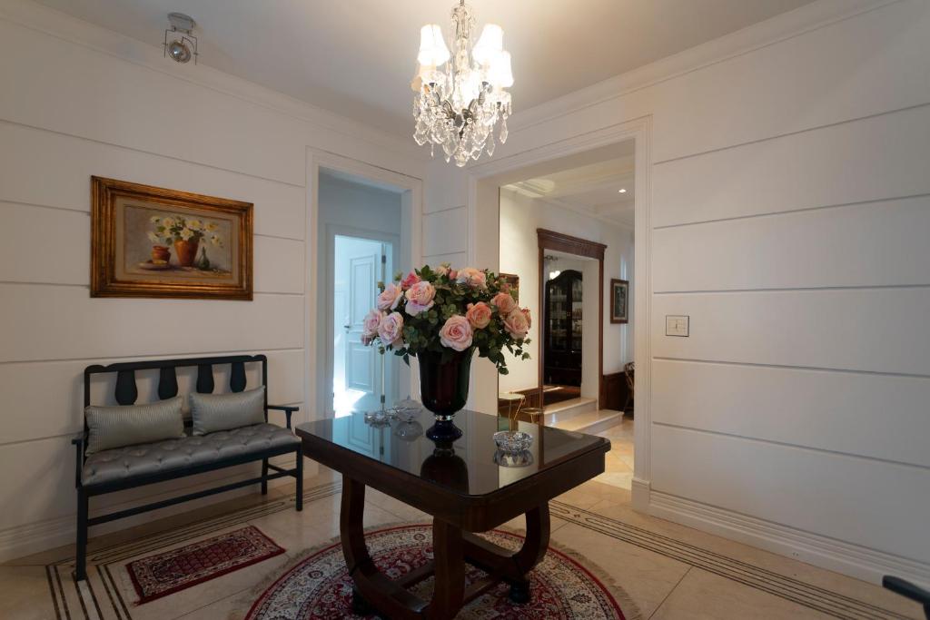里贝朗普雷托Maison Neoclássica 5 estrelas confort的客厅配有带花瓶的桌子