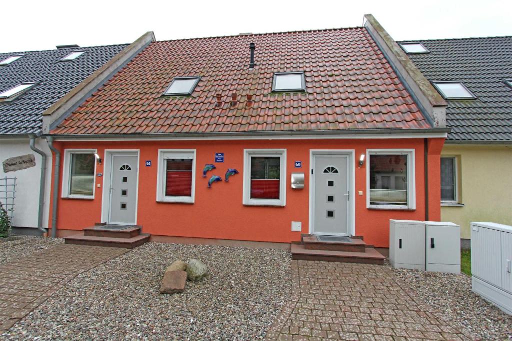 普鲁滕Ferienhaus Pruchten FDZ 311的一间红色的房子,设有白色门和瓷砖屋顶