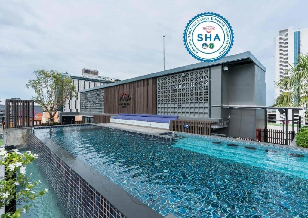 芭堤雅市中心XQ Pattaya Hotel的大楼前的大型游泳池
