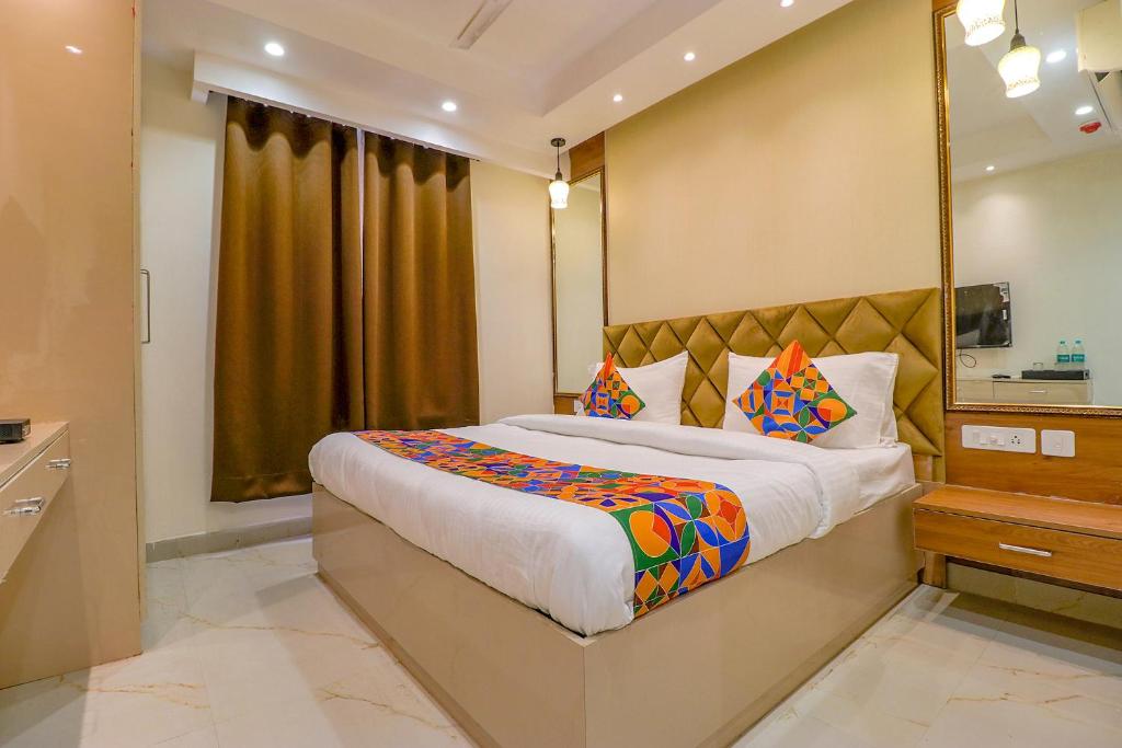 新德里FabHotel F9 Pitampura的一间卧室配有一张大床和镜子