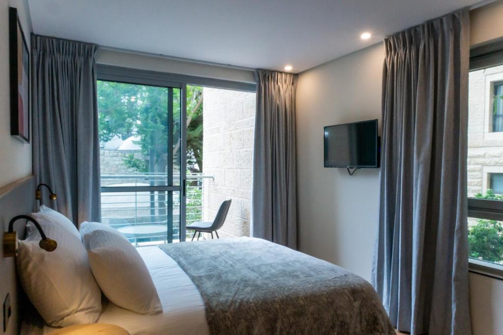 耶路撒冷Urbanic Hotel的一间卧室设有一张床和一个大窗户