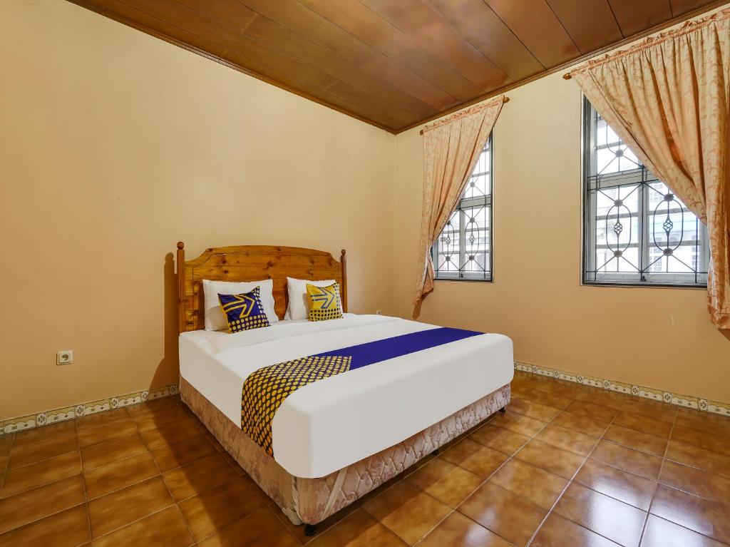 西昆都尔SPOT ON 91107 Villa Galaxy Resort的一间卧室设有一张床和两个窗户。