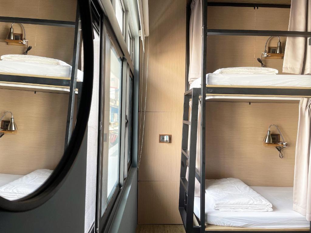 小琉球岛群青所 Gatherers Hostel的一间房间,火车上设有三张双层床
