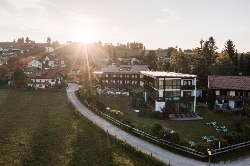 奥伊-米特尔贝格Mittelburg Wellnesshotel的享有小镇的空中景色,拥有房子和太阳