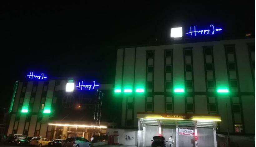 科贾埃利Happy Inn Gebze Hotel的前面有绿色和蓝色的灯光的建筑
