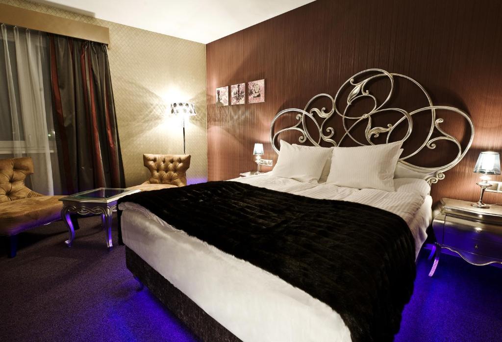 比亚韦斯托克特里奥3号酒店的一间卧室配有一张大床和大床头板