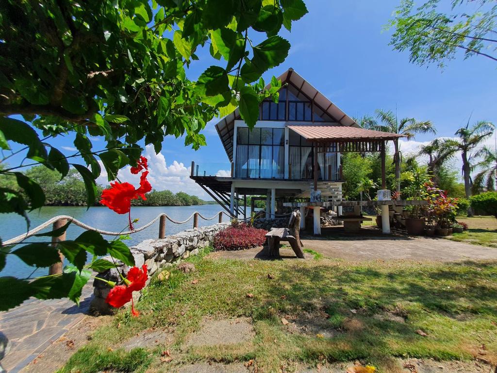 哥打巴鲁哥达巴鲁ALA河景度假屋的水体岸边的房子