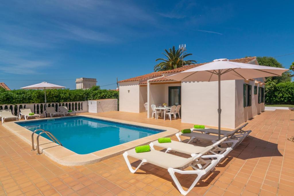 卡拉恩波特Villa Marina -Cala EnPorter-的一个带2把躺椅和遮阳伞的游泳池