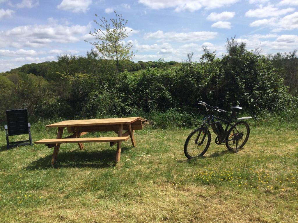 MellionnecEcoCamping d Hacadour的停放在野餐桌和长凳旁的自行车