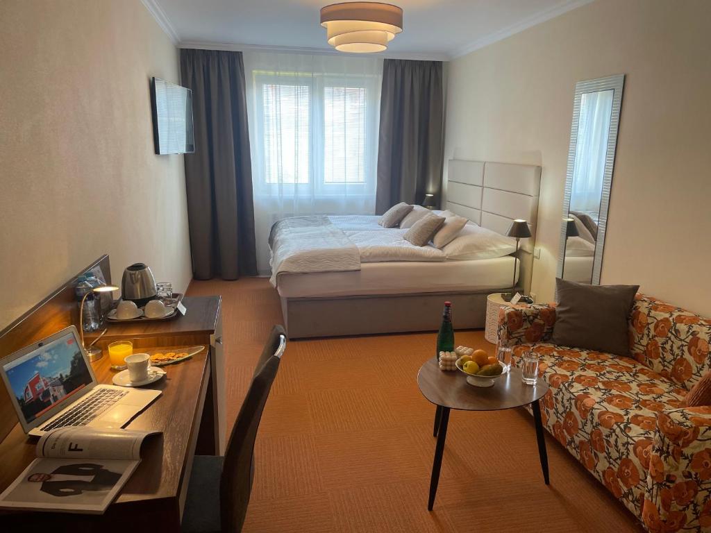 班斯卡-比斯特里察Hotel Garni Expo的配有床、桌子和沙发的房间