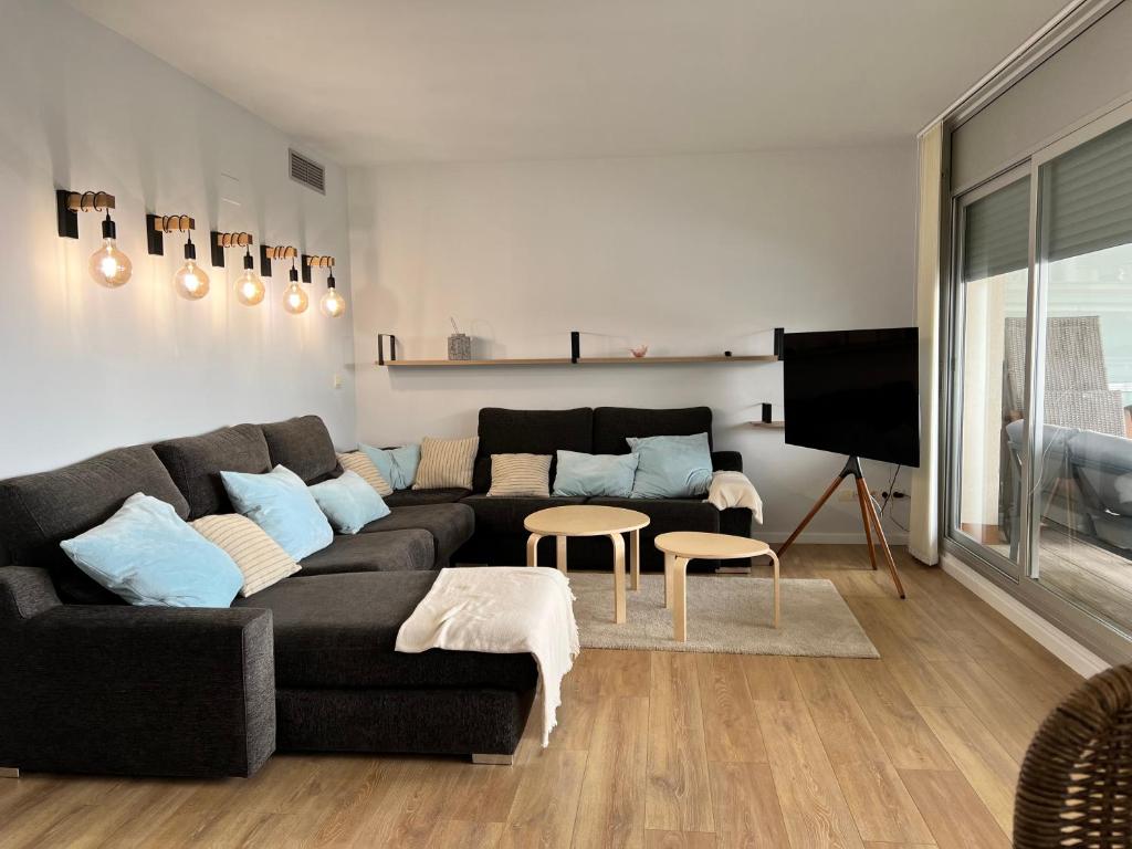圣卡洛斯拉腊皮塔Apartament Montsià的客厅配有黑色沙发和电视