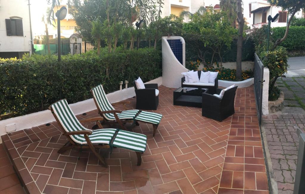 斯卡莱阿Casa vacanze Maradei的庭院配有两把椅子、一张桌子和一张沙发