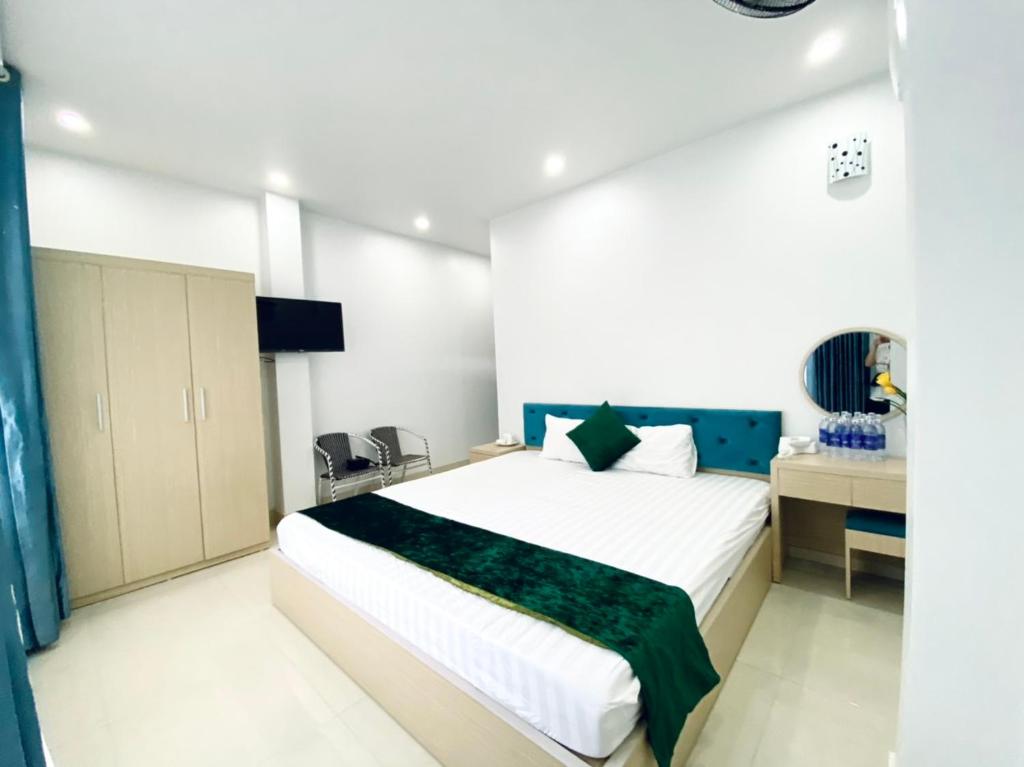 吉婆岛Ngoc Ha Hotel的一间卧室配有一张大床和一张书桌