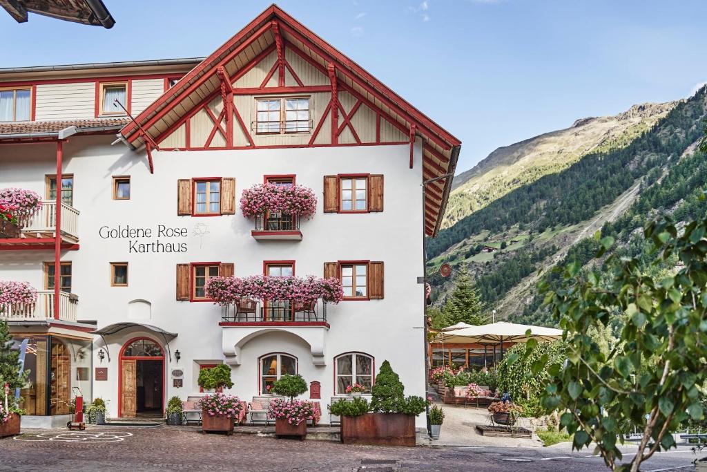 塞纳莱斯Goldene Rose Karthaus a member of Small Luxury Hotels of the World的山上的建筑,窗户上有鲜花