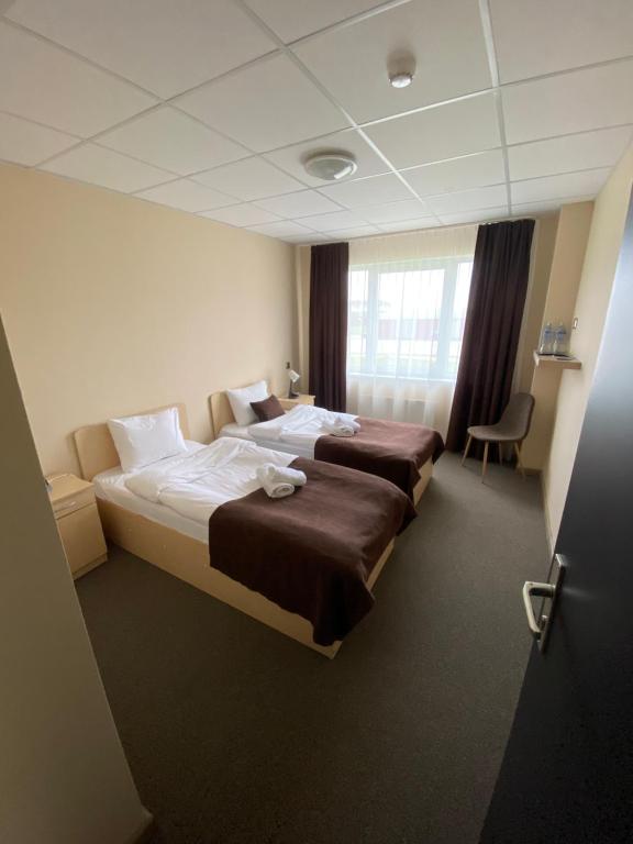 AizkraukleVILARHOTEL的酒店客房设有两张床和窗户。