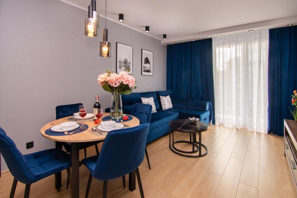 格但斯克Maya's Flats & Resorts 50 - Aura 40的客厅配有桌子和蓝色沙发