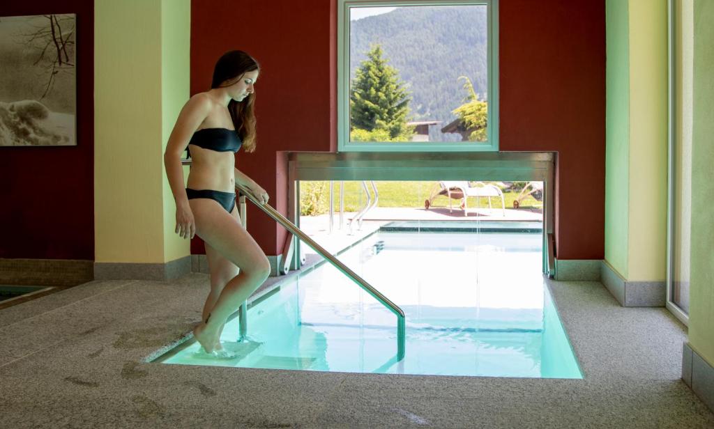 维哥迪法萨Nature Wellness Hotel Renato的站在游泳池里的比基尼的女人