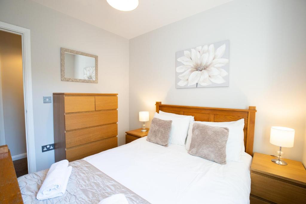 霍兹登Velvet 2-bedroom apartment, Brewery Road, Hoddesdon的卧室配有白色的床和两盏灯。