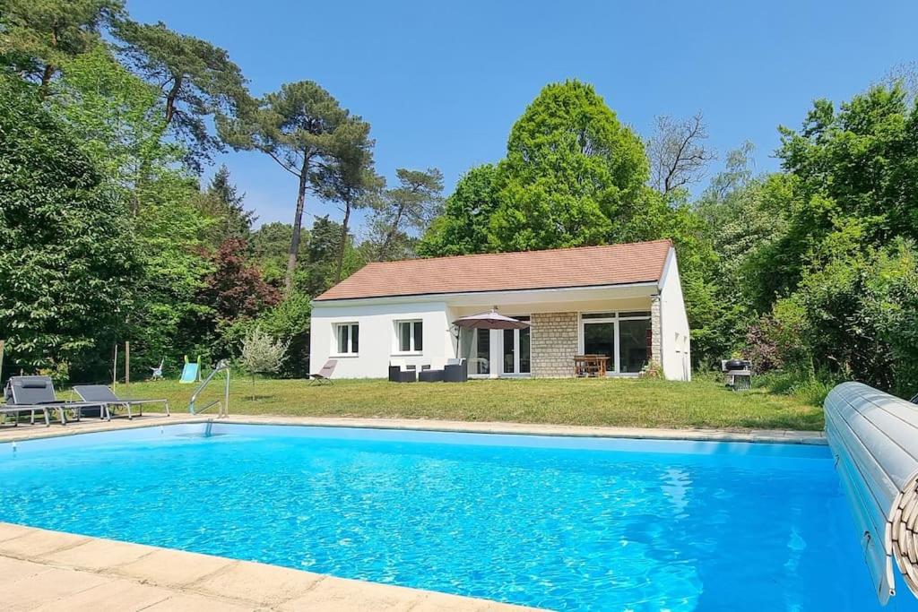 Villiers-sous-GrezJolie maison en pleine nature的房屋前有游泳池的房子
