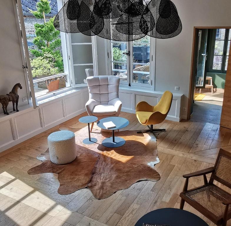 索姆河畔的圣瓦列里Maison d'hôtes du Jardin的客厅配有桌椅和叶毯