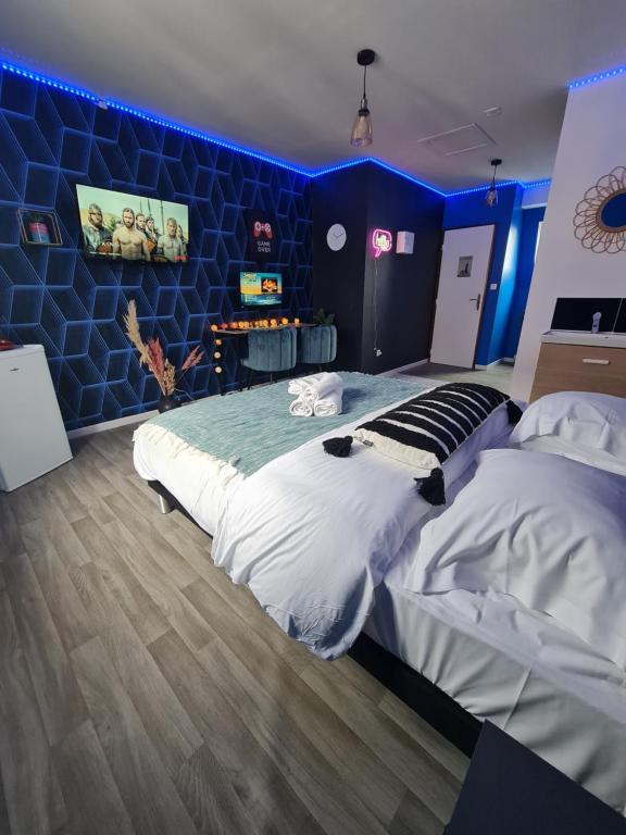 鲁贝NG SuiteHome - Lille I Roubaix Centre I 121 - Gamer - Arcade de jeux - Netflix - Wifi的一间卧室设有一张大床和蓝色的墙壁