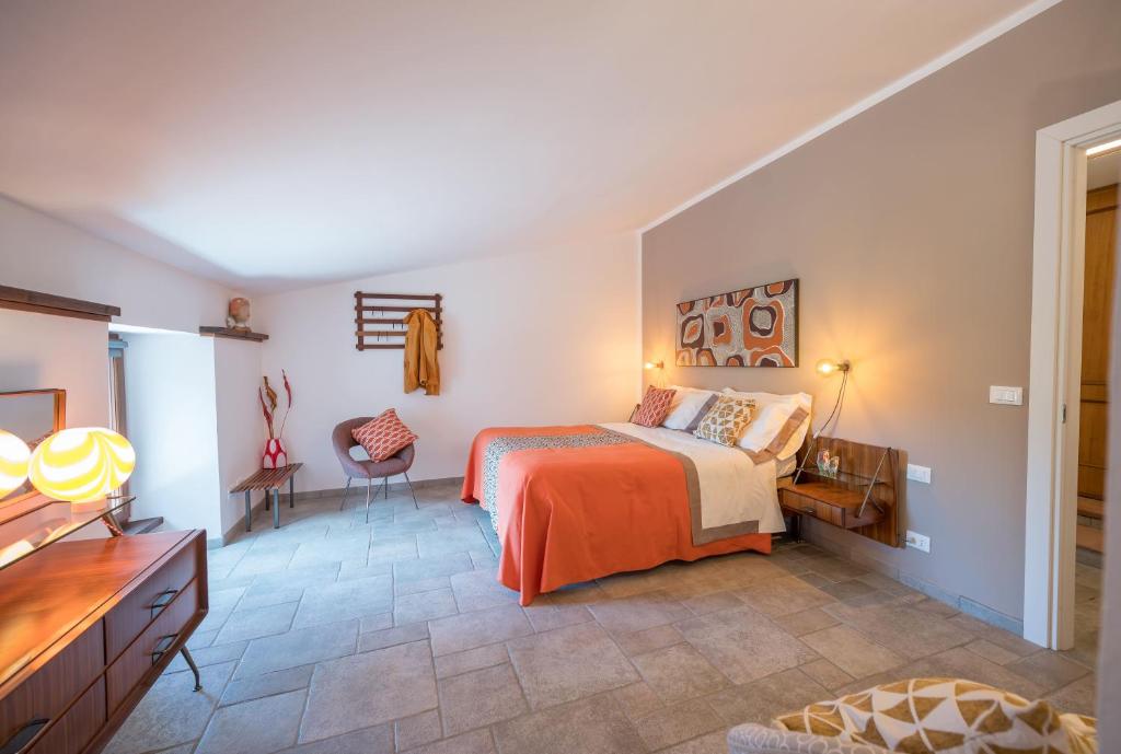 Tagliolo MonferratoCascina Gazzeri Country House的卧室配有一张床、一张桌子和椅子