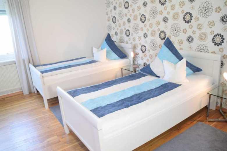 FreirachdorfDEB 035 Ferienwohnung im Westerwald的一间卧室配有两张带蓝白色枕头的床