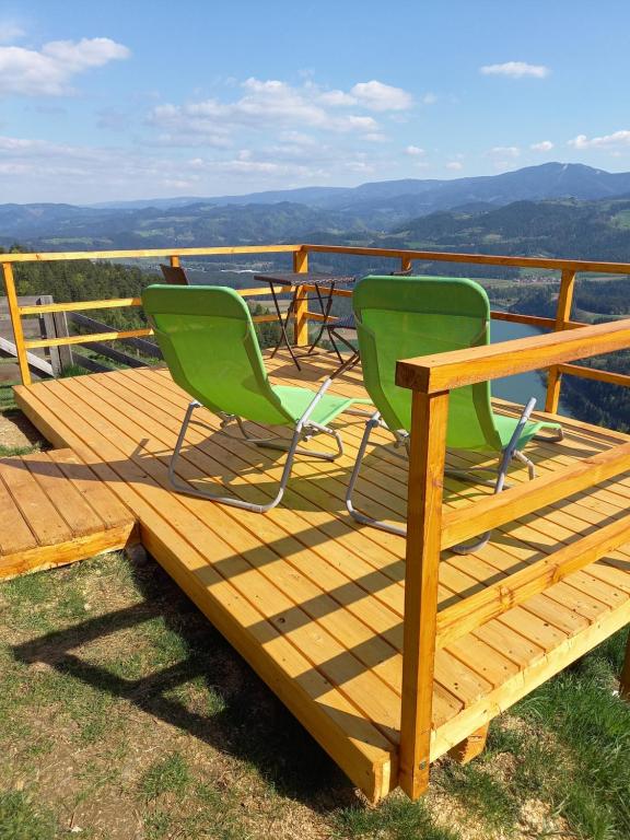 MutaGlamping hišice Orlič的观景甲板上配有两把椅子和一张桌子