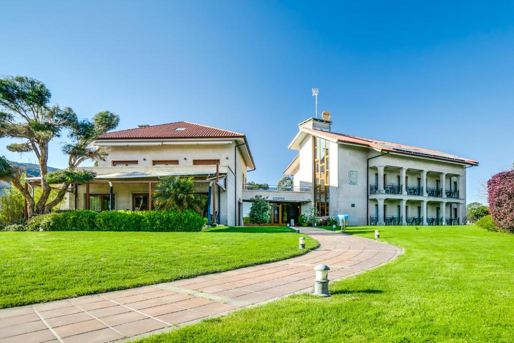 庞特维德拉Hotel Rural Campaniola的一座大房子,旁边是草地庭院