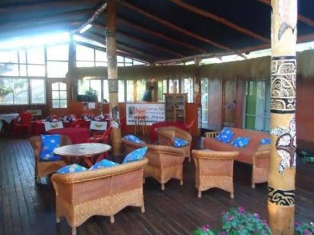 安加罗阿Kaimana Inn Rapa Nui的一间在房间内配有桌椅的餐厅
