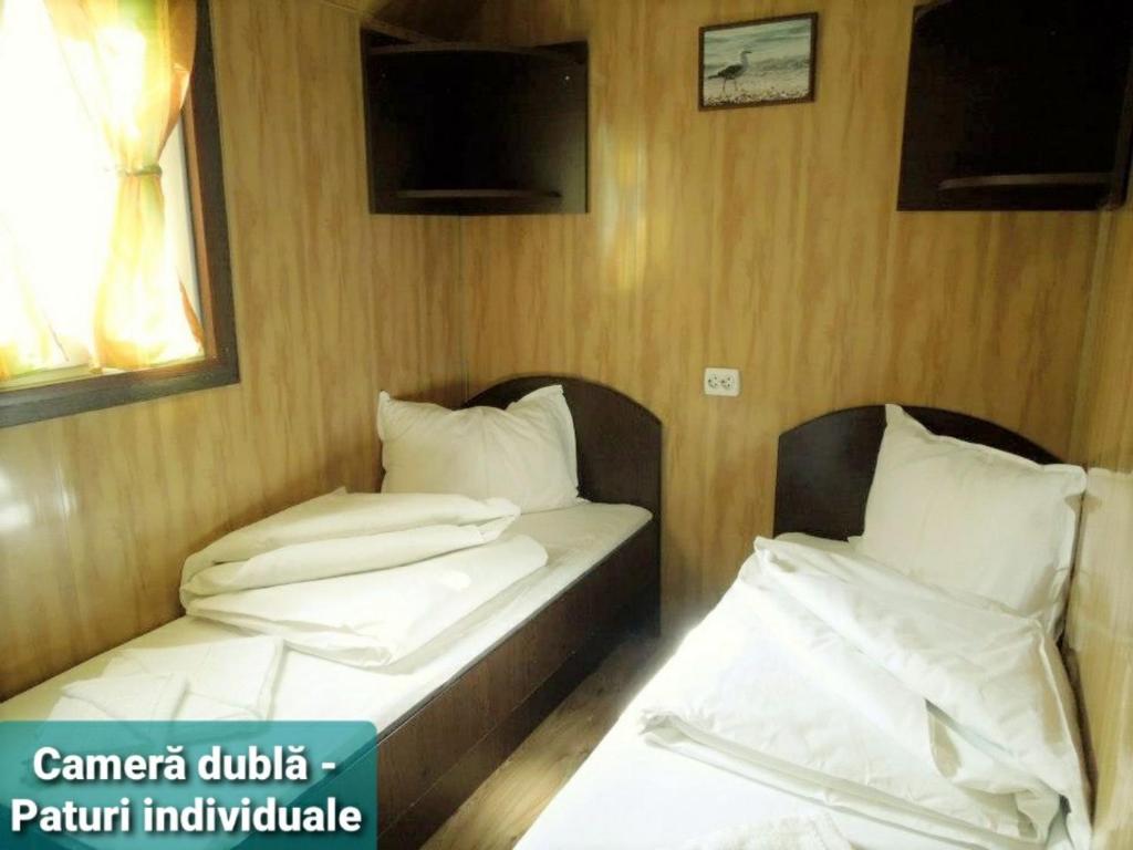 NufăruHotel Restaurant Plutitor Delta Ways的配有电视的客房内的两张单人床