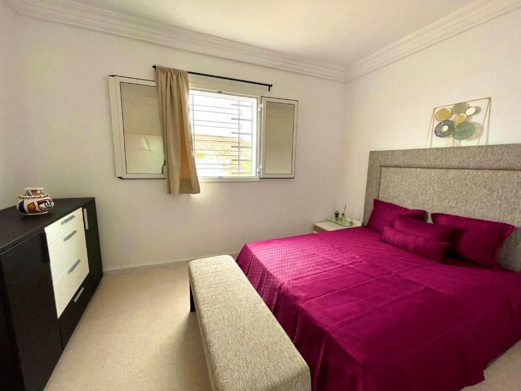 哈马马特Soltane Résidence的卧室设有一张粉红色的大床和一扇窗户。