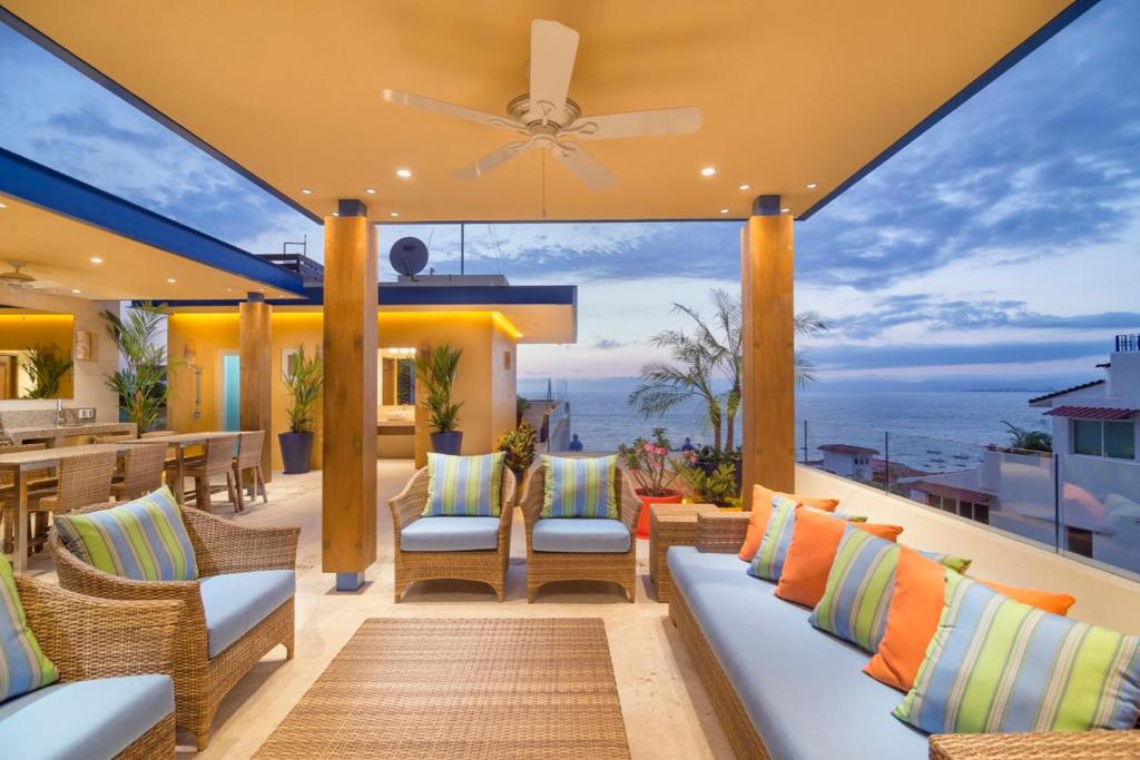 巴亚尔塔港LOS MUERTOS BEACH SUITE 101的户外庭院配有椅子和吊扇