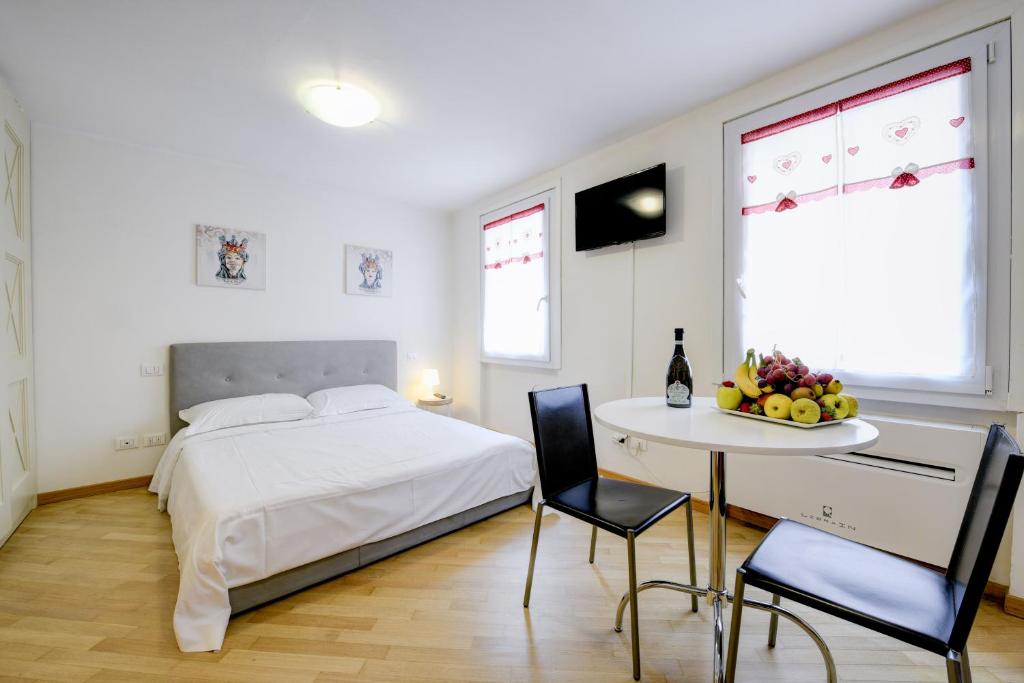 西尔米奥奈Appartamenti Anna的一间卧室配有一张床和一张桌子及椅子