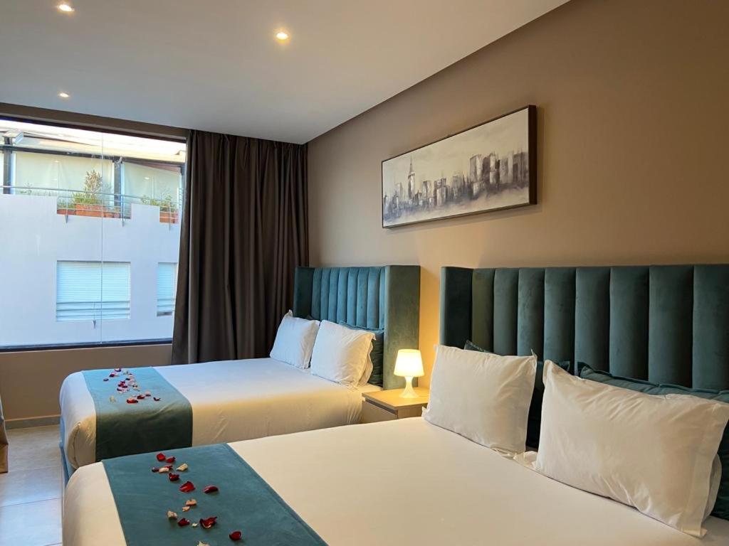 拉巴特Atlas-Résidence by Rent-Inn的酒店客房设有两张床和窗户。