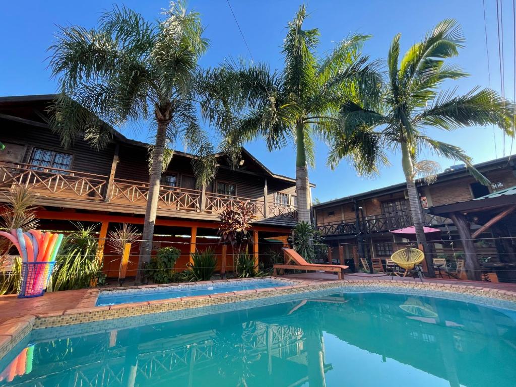 伊瓜苏港Tierra Viva的棕榈树屋前的游泳池