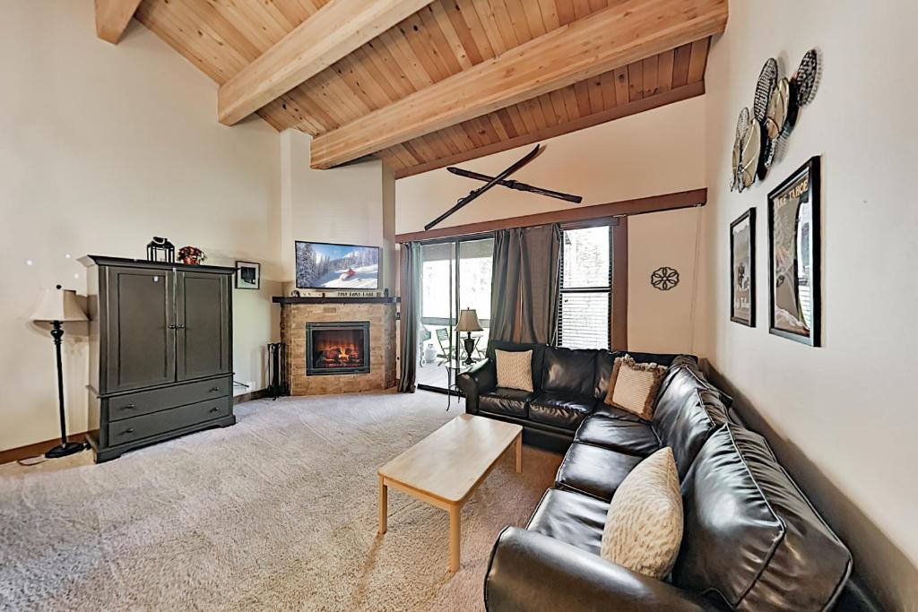 特拉基Aspen Grove Condo的客厅设有真皮沙发和壁炉