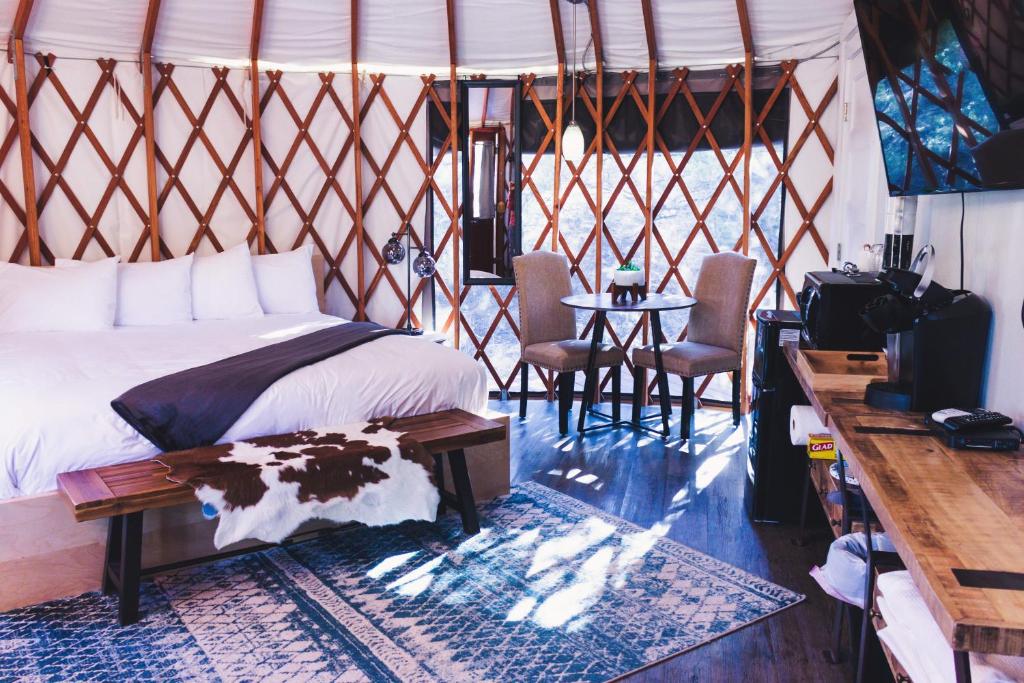 埃斯卡兰特Escalante Yurts - Luxury Lodging的卧室配有一张床和一张桌子及椅子