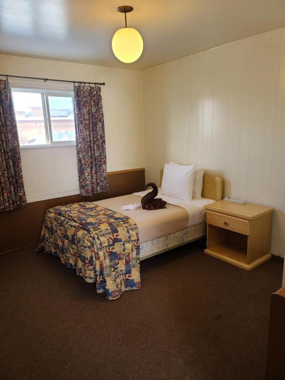 道森克里克Midtown Motel on Alaska Ave的酒店客房设有床和窗户。