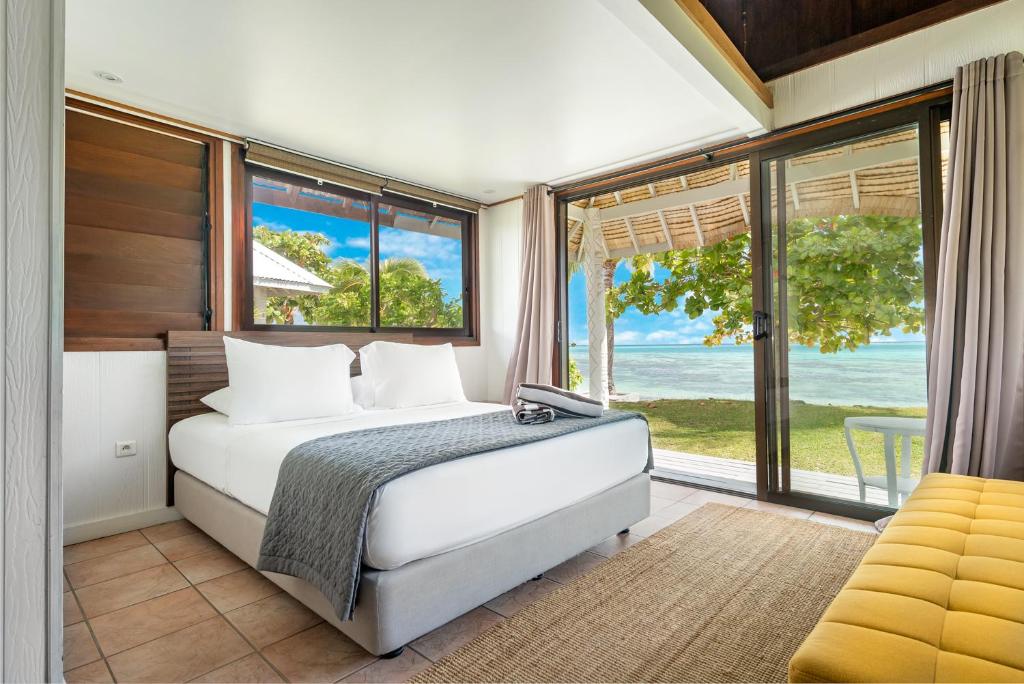 莫雷阿Moorea Island Beach Hotel的一间卧室设有一张床和一个大窗户