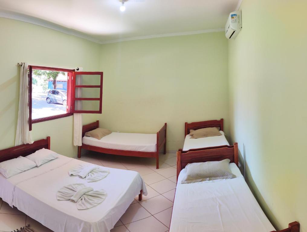 博尼图Pousada Voo das Garças的客房设有两张床和窗户。