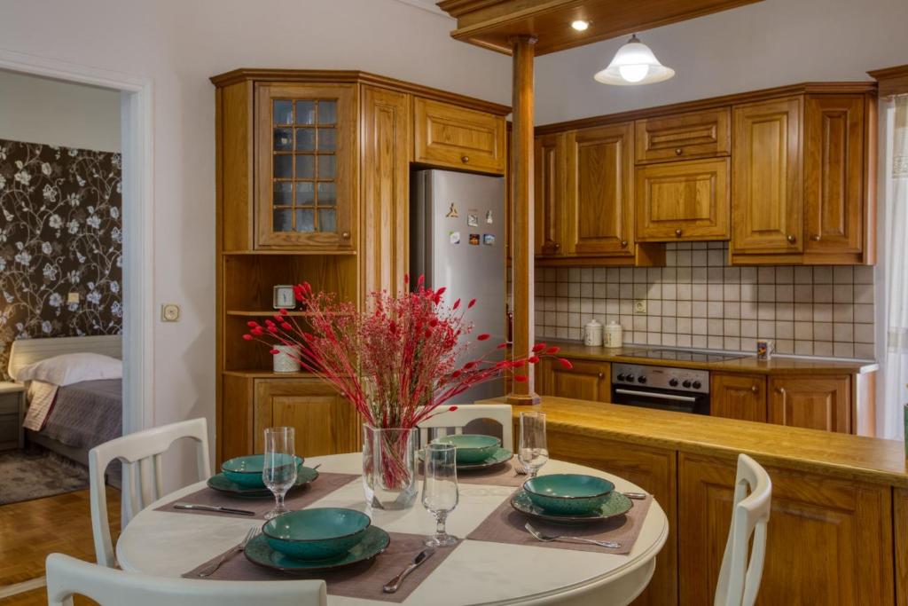 AnemómylosHelena Aparment的厨房配有桌椅和冰箱。
