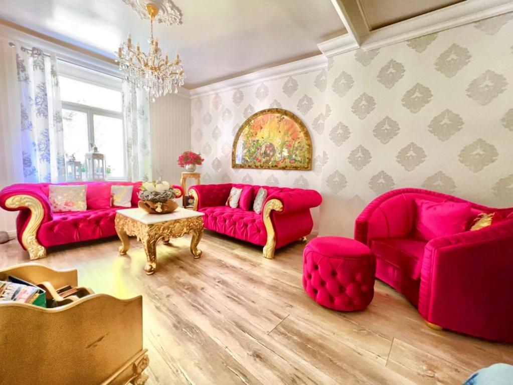巴登韦勒Boutiquehotel Villa Rosenhof的客厅配有粉红色的沙发和桌子