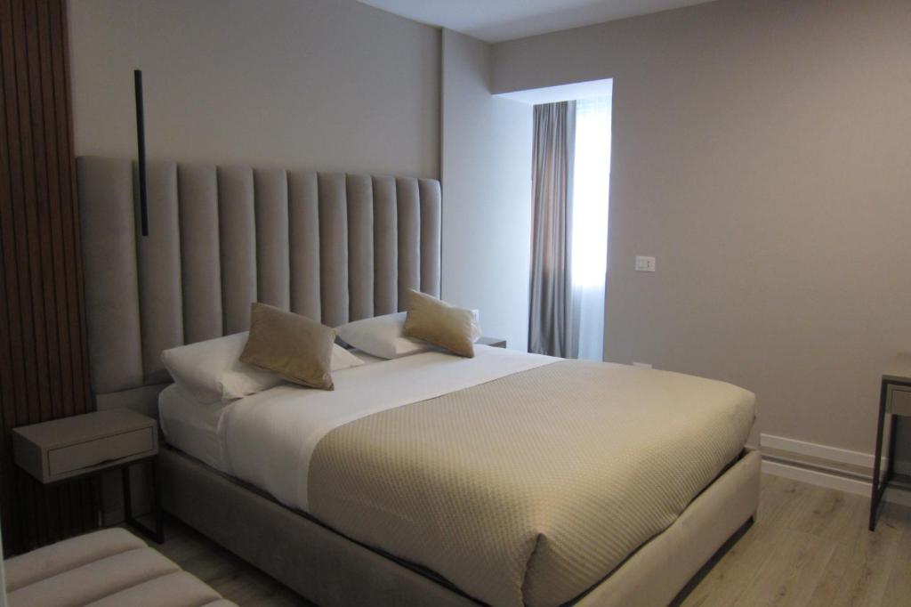 地拉那弗雷迪酒店的窗户客房内的一张白色床