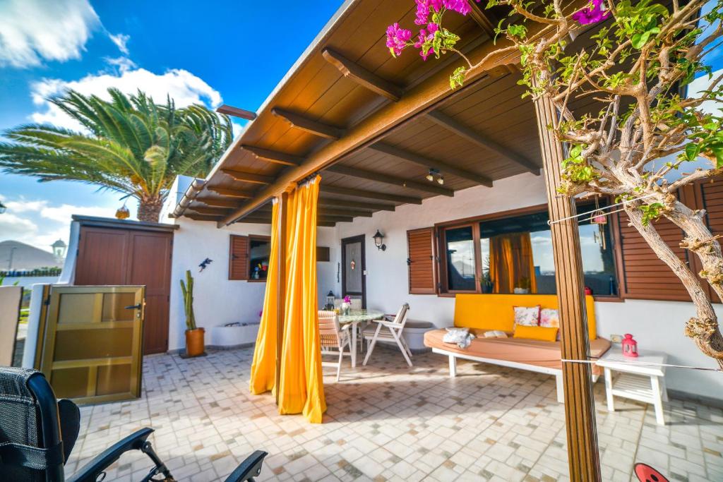 特吉塞Casa Tamai, ideal para familias en el centro de la isla的户外庭院配有黄色窗帘和桌子