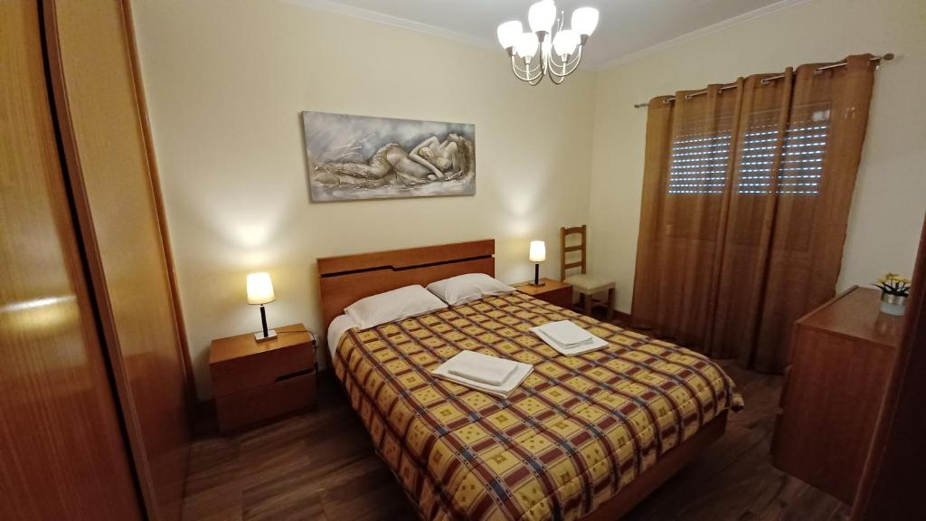 蓬塔德尔加达Dona Matilde的一间卧室配有一张带两张桌子和两盏灯的床。