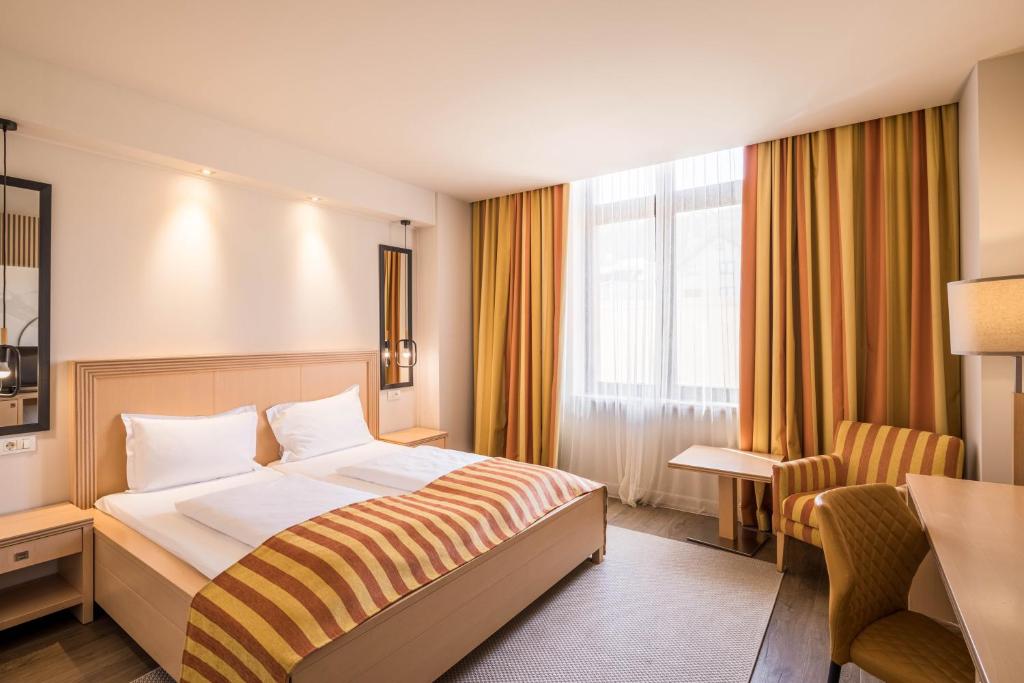 雷希察罗格酒店的配有一张床和一张书桌的酒店客房