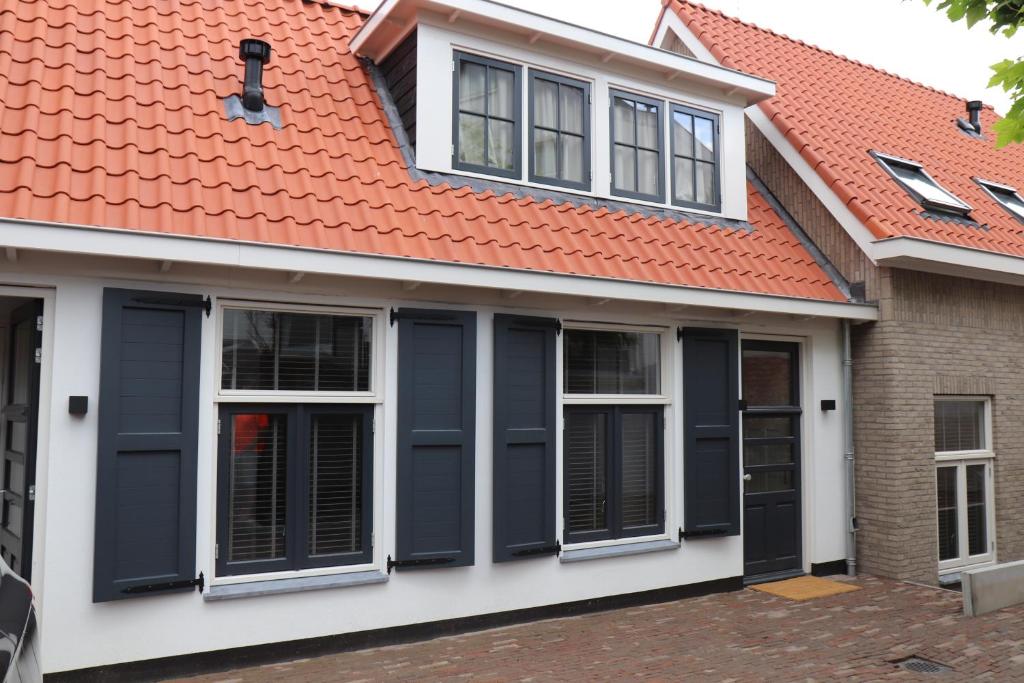 赞德沃特Guesthouse Bonniehofje的一座带橙色屋顶和黑色百叶窗的房子