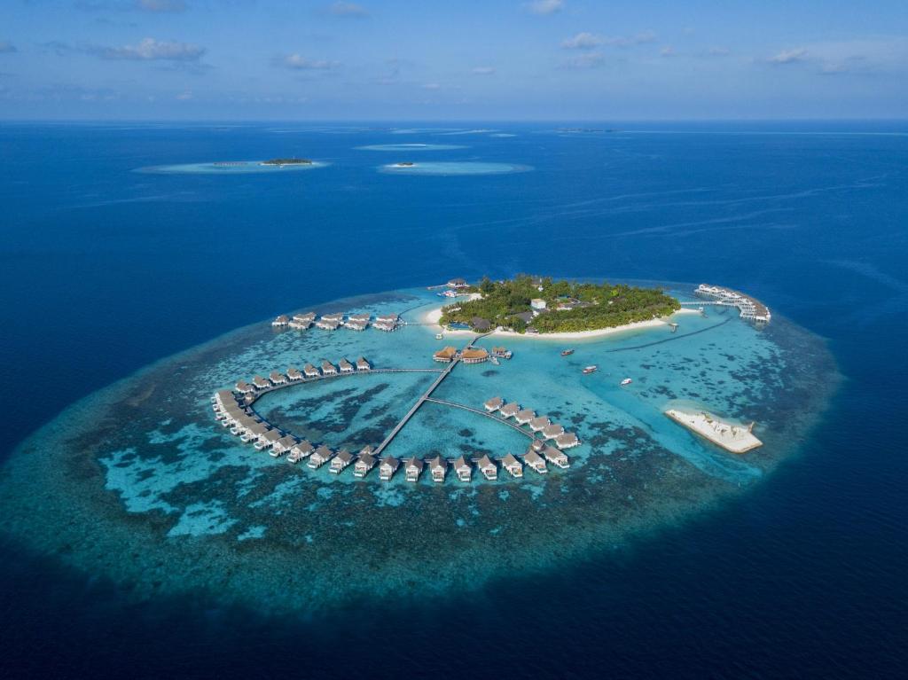 MachchafushiCentara Grand Island Resort & Spa的海中的一个岛屿,水中有船只