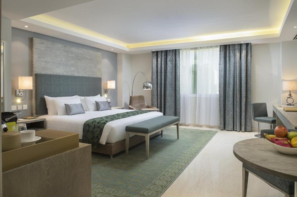马斯喀特阿曼森特马斯喀特酒店的酒店客房设有床和客厅。